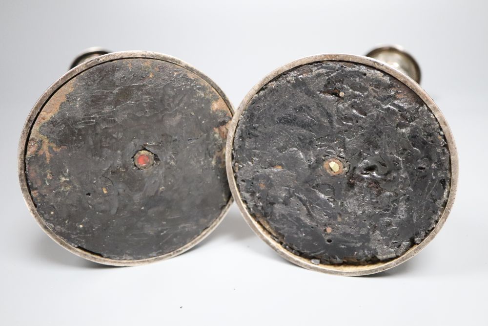 A pair of late George III silver candlesticks, with later embossed decoration, Soloman Hougham, London 1817,